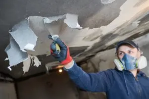 Fire Repair Contractor Removing Burnt Drywall from Ceiling